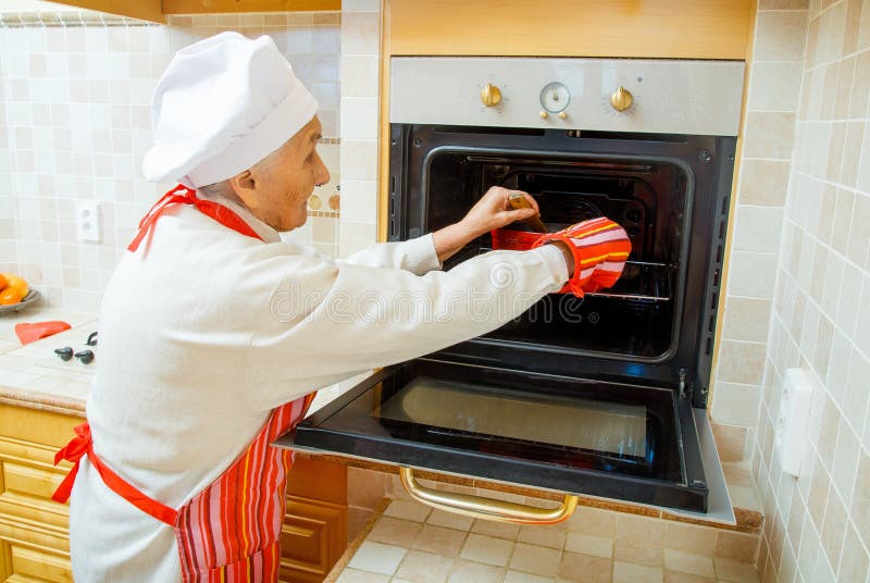 Ηλικιωμένο ψήσιμο γυναικών νεράιδων κουζινών yummies στο σπίτι στοκ φωτογραφία